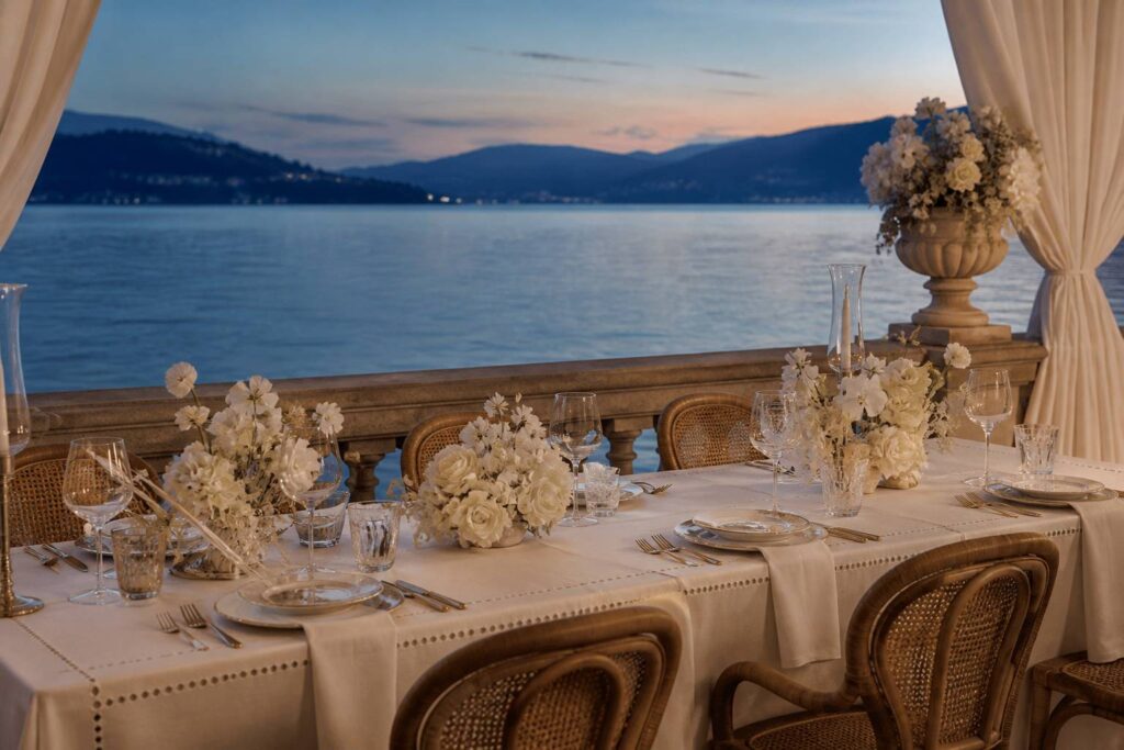 Table de mariage élégante face à un lac au crépuscule